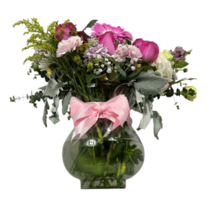 Arreglo en jarrón de vidrio con tulipanes y gerbera rosa, flores mixtas pastel, gypsophila y luces LED, con lazo rosa.