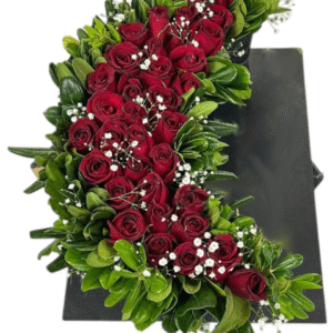 Arreglo de rosas rojas en media luna con gypsophila (velo de novia) y follaje verde sobre base negra.