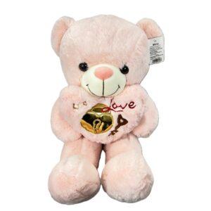 Peluche oso rosa claro con cojín de corazón, bordado “Love” y detalle de candado y llave dorados.