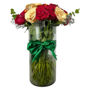 Jarrón cilíndrico de vidrio con rosas rojas y durazno, eucalipto y follaje gris, con lazo verde.